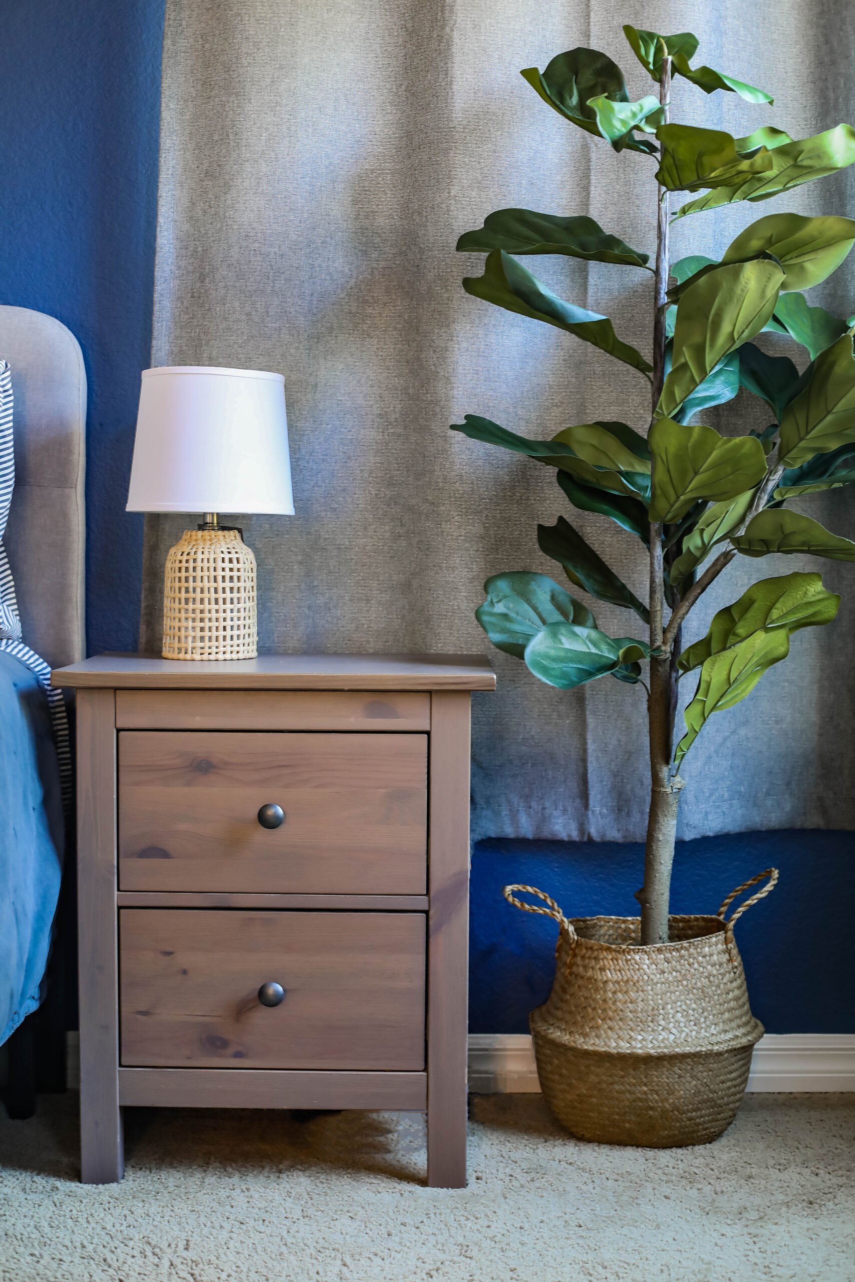 Looking for navy and grey bedroom decor? I love how the faux fiddle leaf tree adds a pop of color to the bedroom, and those rattan lamps are PERFECT!